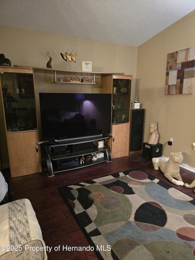 living room with dark wood-type flooring and a textured ceiling