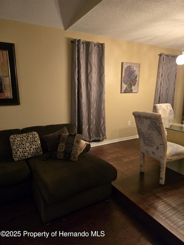 living room with dark hardwood / wood-style flooring and a textured ceiling