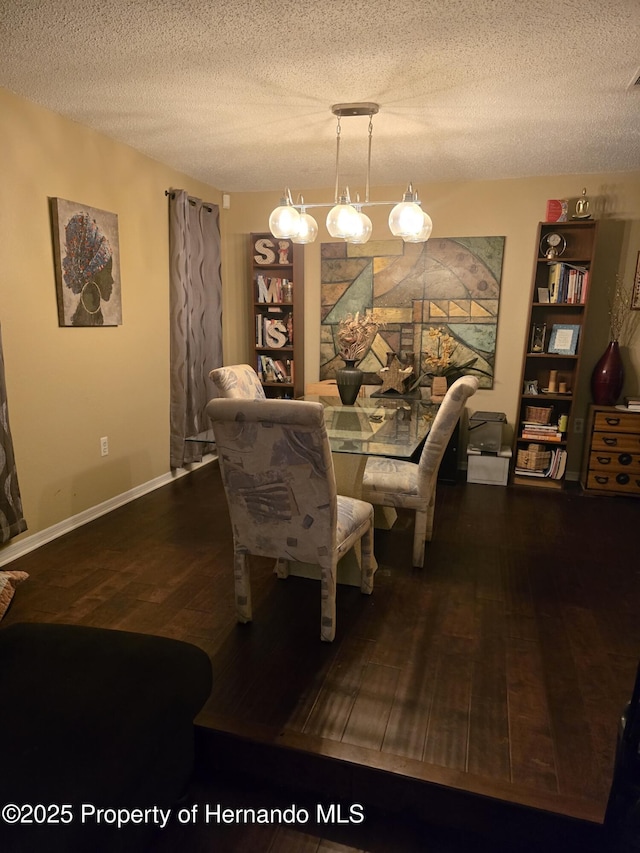 dining space with hardwood / wood-style flooring and a textured ceiling