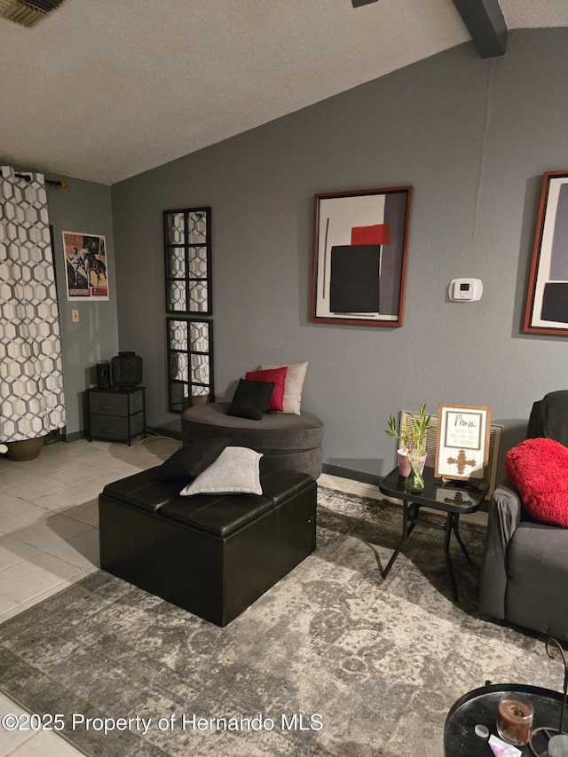 living room featuring vaulted ceiling, tile patterned floors, and a textured ceiling