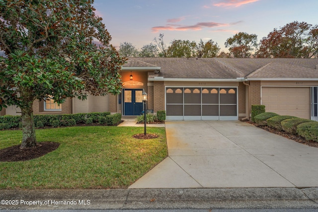 view of front of home with a garage and a lawn