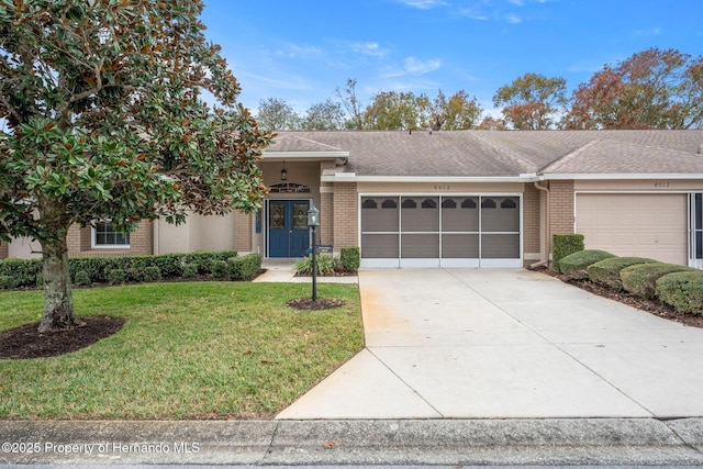 ranch-style house with a garage and a front lawn