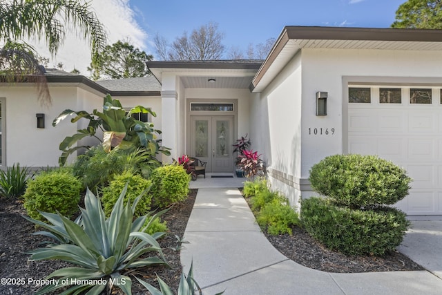 view of exterior entry featuring french doors and a garage