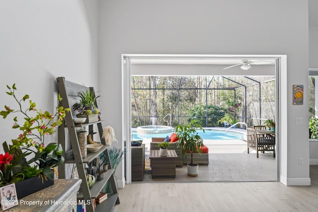 living area with light hardwood / wood-style flooring, a wealth of natural light, and ceiling fan