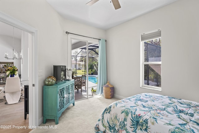 carpeted bedroom with ceiling fan with notable chandelier and access to outside