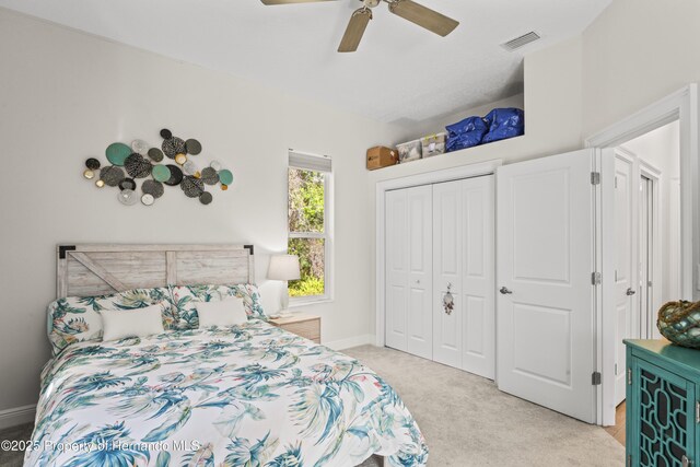 carpeted bedroom with ceiling fan and a closet