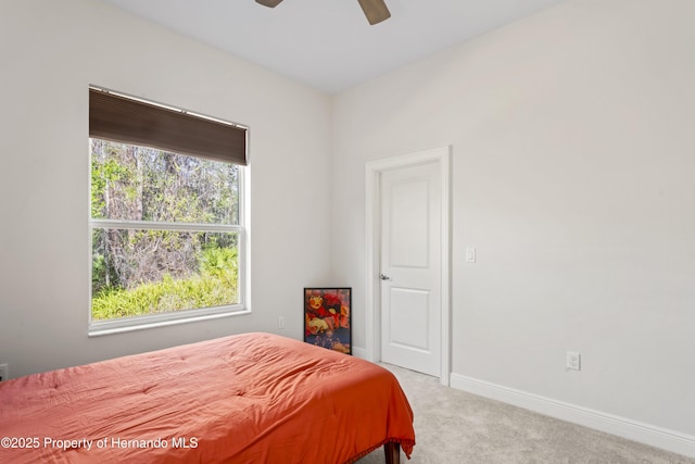 carpeted bedroom featuring multiple windows and ceiling fan