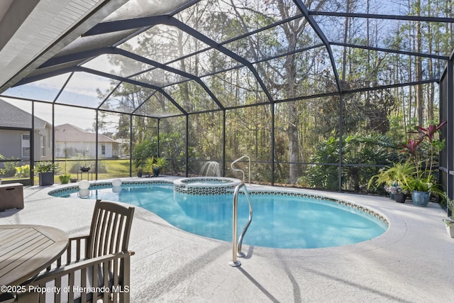 view of pool featuring an in ground hot tub, glass enclosure, and a patio area