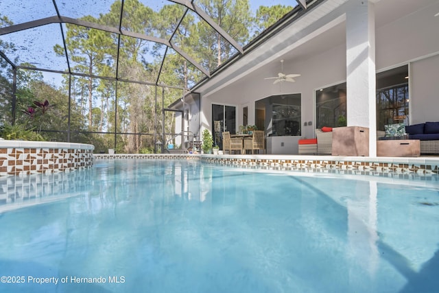 view of pool with glass enclosure and ceiling fan