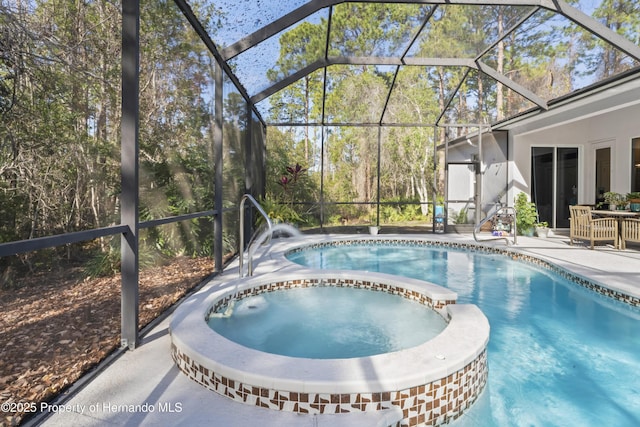 view of swimming pool featuring an in ground hot tub, a patio, and a lanai