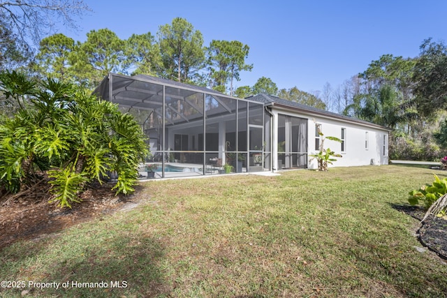 back of house featuring glass enclosure and a yard