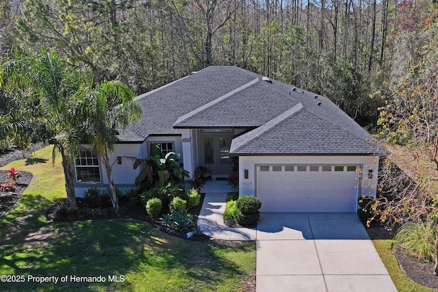 view of front of property featuring a garage and a front lawn