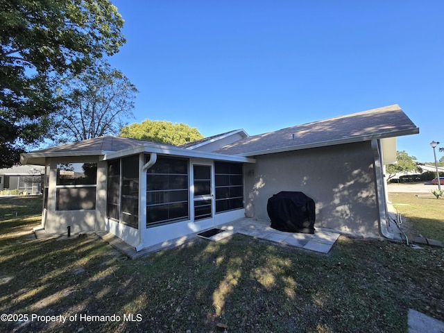 back of house featuring a sunroom and a yard