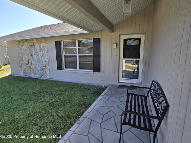 property entrance with a lawn and a patio