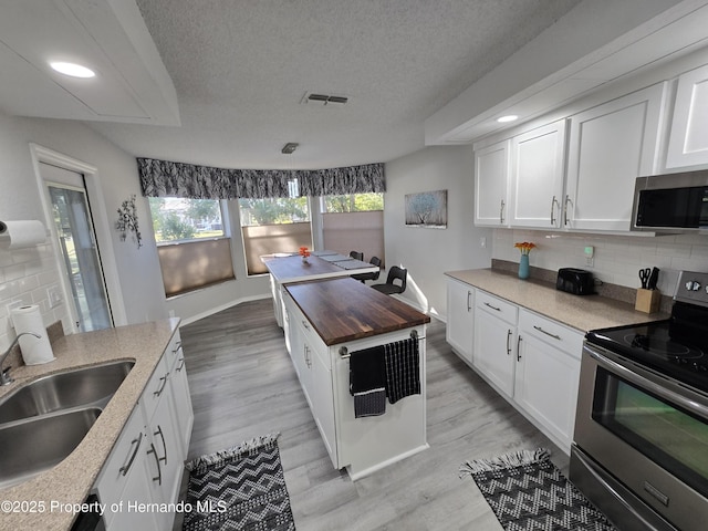 kitchen with white cabinets and appliances with stainless steel finishes