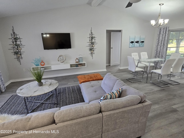 living room with hardwood / wood-style flooring, vaulted ceiling with beams, and ceiling fan with notable chandelier