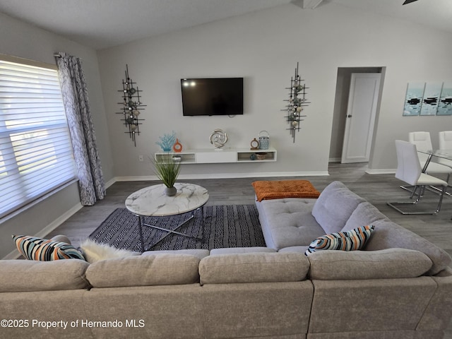 living room with hardwood / wood-style floors and vaulted ceiling with beams