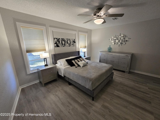 bedroom featuring ceiling fan, dark hardwood / wood-style flooring, and a textured ceiling