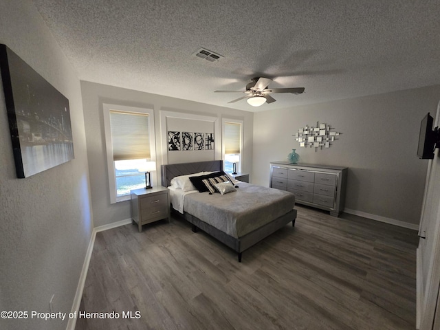 bedroom featuring a textured ceiling, dark hardwood / wood-style flooring, and ceiling fan