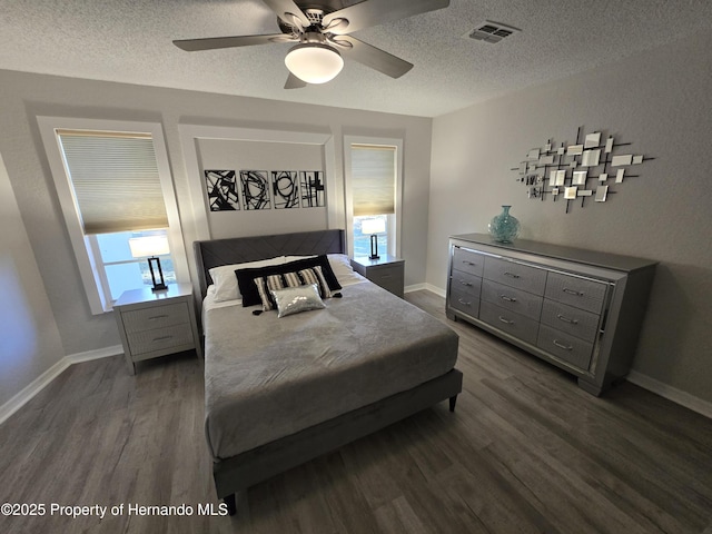 bedroom with ceiling fan, dark hardwood / wood-style flooring, and a textured ceiling