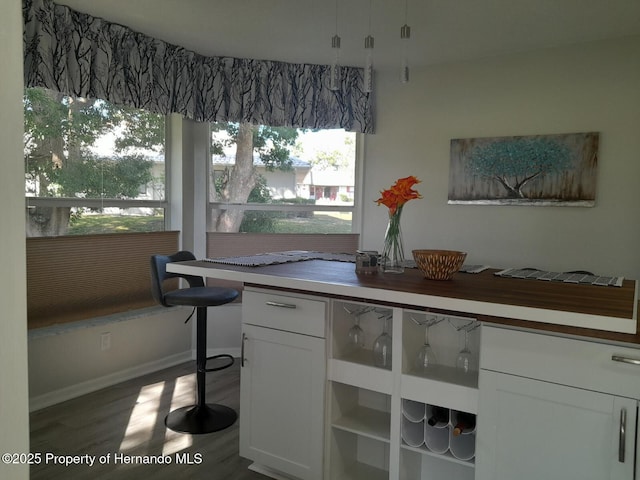 interior space with dark hardwood / wood-style flooring, butcher block countertops, and white cabinetry