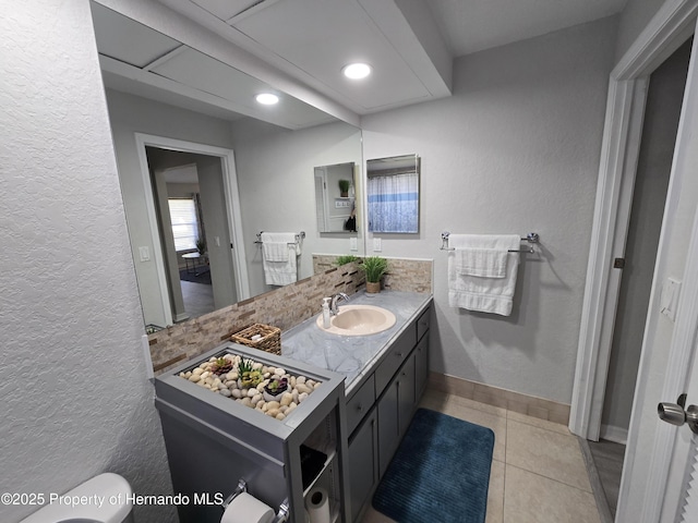 bathroom with tile patterned flooring, vanity, and toilet