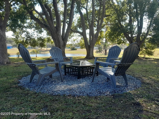 view of yard with a water view and a fire pit