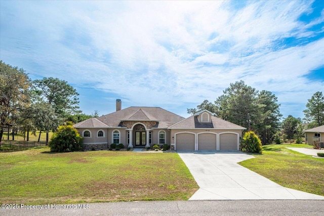 view of front facade featuring an attached garage, driveway, and a front yard