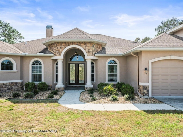 view of front of property with stone siding, roof with shingles, french doors, and stucco siding