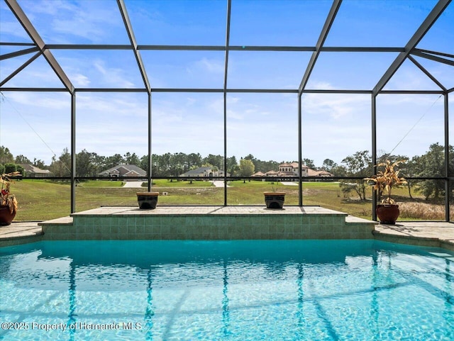 outdoor pool with a patio area, glass enclosure, and a yard