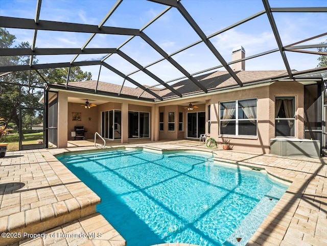 outdoor pool featuring glass enclosure, ceiling fan, grilling area, and a patio