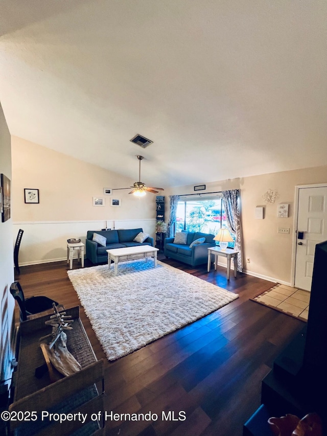 living room with hardwood / wood-style flooring, vaulted ceiling, and ceiling fan