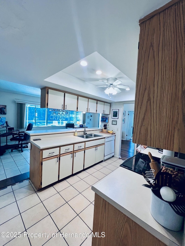 kitchen featuring ceiling fan, sink, light tile patterned floors, white dishwasher, and white cabinets