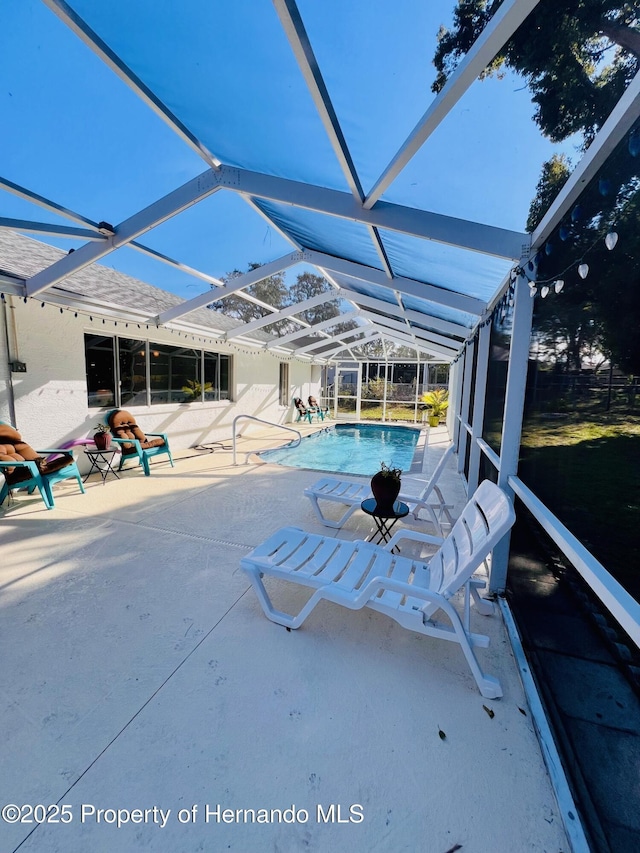 view of pool with a patio area and a lanai