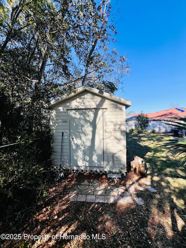 view of side of home with a shed