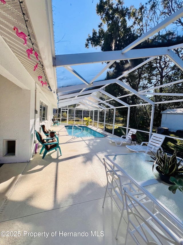 view of swimming pool with glass enclosure and a patio area