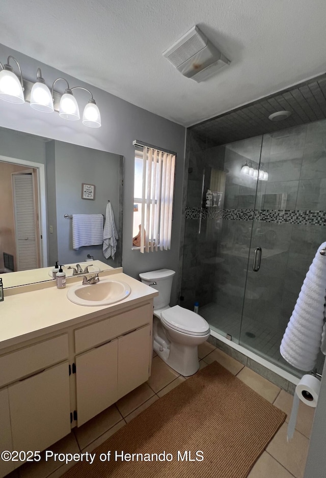 bathroom with tile patterned flooring, vanity, toilet, and an enclosed shower