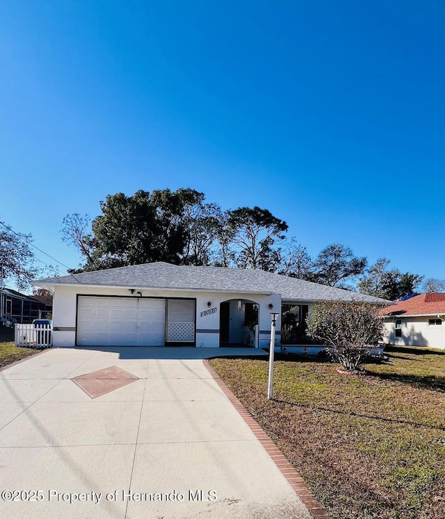 single story home featuring a front yard and a garage