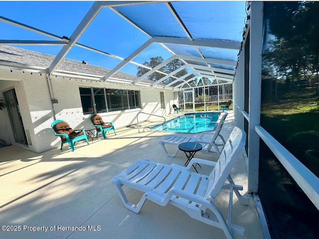 view of swimming pool with glass enclosure and a patio area