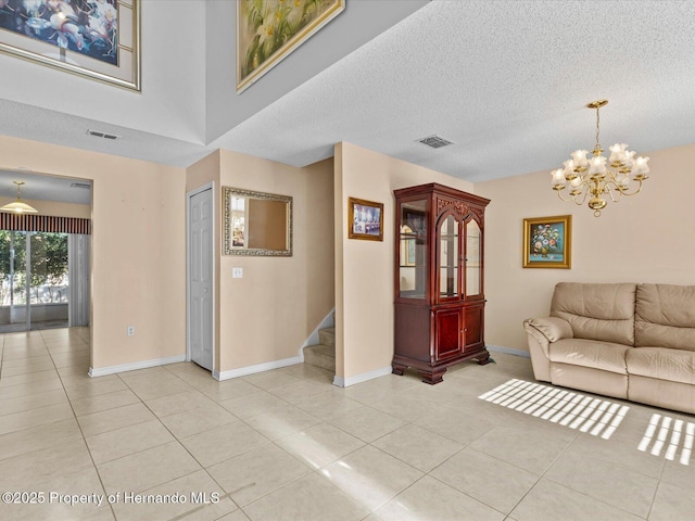 tiled living room with a chandelier and a textured ceiling