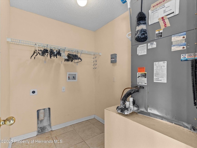 washroom featuring electric dryer hookup, tile patterned floors, heating unit, hookup for a washing machine, and a textured ceiling