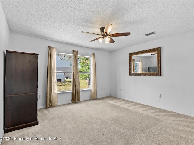 spare room with light carpet, a textured ceiling, and ceiling fan