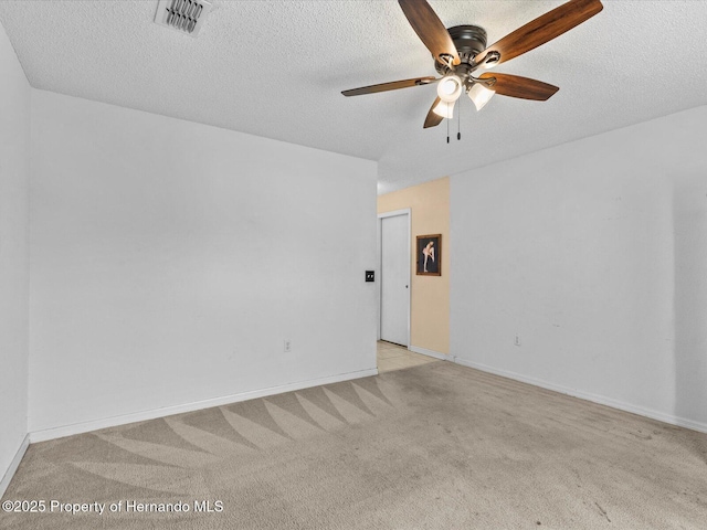 empty room featuring a textured ceiling, ceiling fan, and light carpet