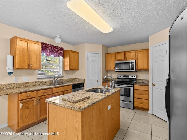 kitchen featuring sink, a center island with sink, light tile patterned floors, and appliances with stainless steel finishes