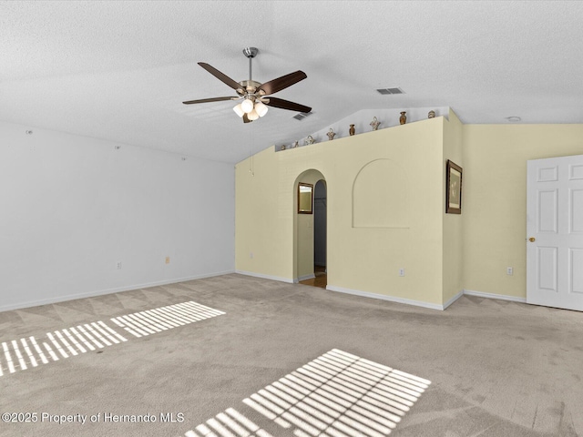 unfurnished living room with a textured ceiling, ceiling fan, lofted ceiling, and light carpet