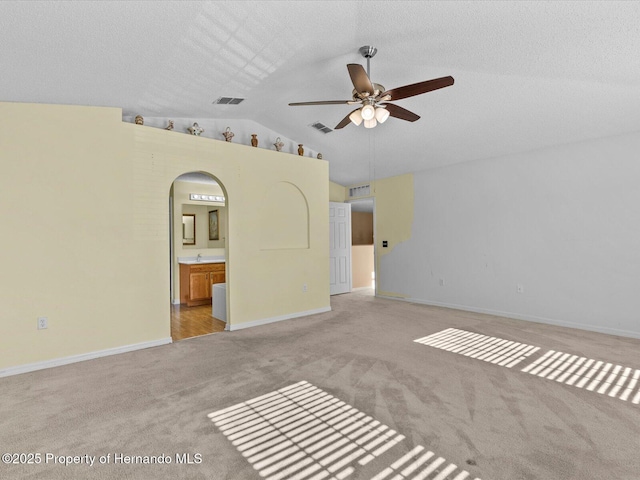 carpeted spare room with vaulted ceiling and ceiling fan