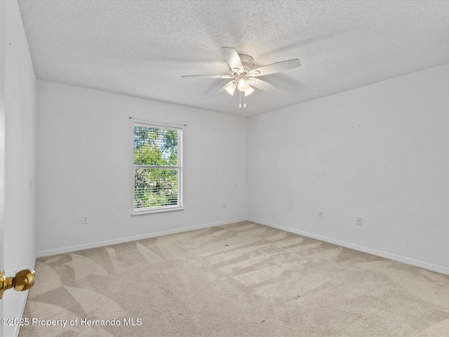 empty room with a textured ceiling, light colored carpet, and ceiling fan