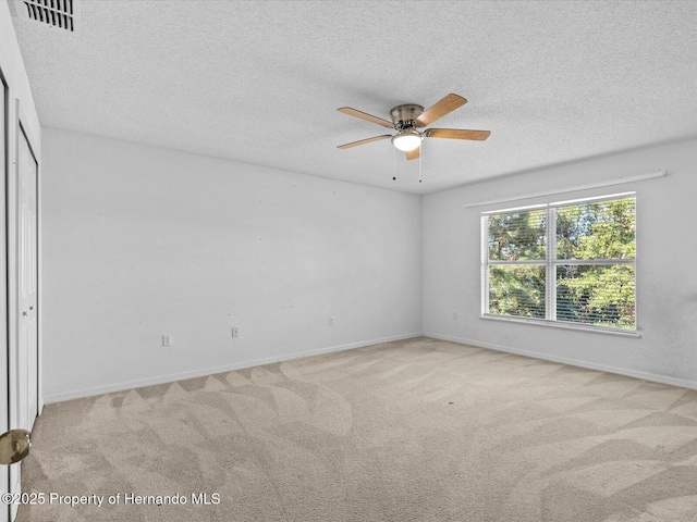 interior space with a closet, a textured ceiling, light colored carpet, and ceiling fan