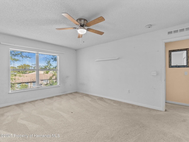 empty room with a textured ceiling, ceiling fan, and light carpet