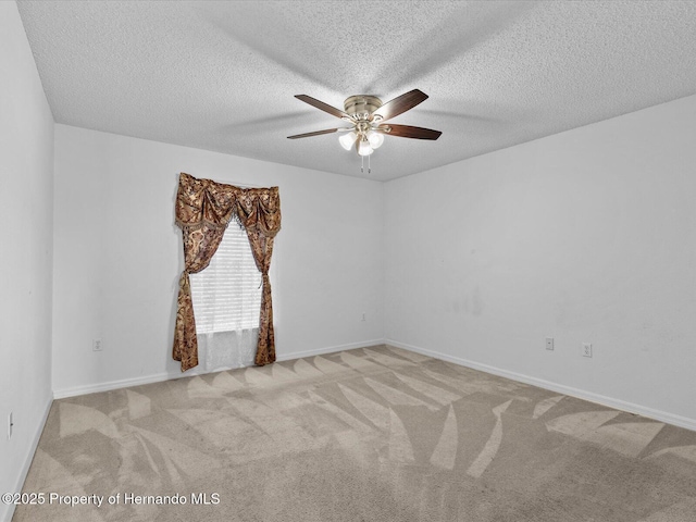 carpeted spare room featuring ceiling fan and a textured ceiling